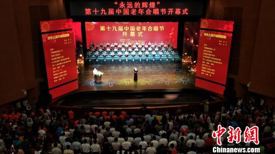 全体起立合唱国歌。 徐志雄 摄